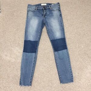 Light wash blue skinny jeans with dark accents.